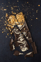 Dark chocolate bark isolated on a dark background. Top view, flat lay.