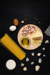 Traditional Italian pasta Carbonara ingredients: bacon, spaghetti, parmesan, cheese, eggs, garlic, cream and olive oil. Top View, flat lay.
