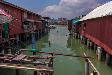 Fototapeta na wymiar The clan jetties stretch out across the water to modern tower blocks in the distance in George Town, Penang Island, Malaysia, Asia