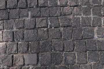 Pavement texture. Old paving stone mosaic pattern. Gray cobblestone sidewalk background. Rough granite textured road construction. Paved cobble exterior. Paving city street