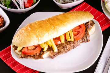 A delicious doner donair kebab in bread with spicy meat, lettuce, tomato, red onion and sauce.