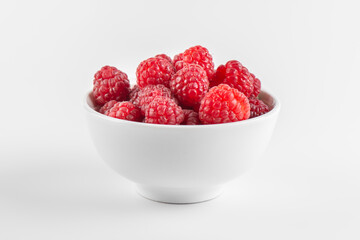 Fototapeta na wymiar Fresh raspberries in a bowl isolated on white background, side view