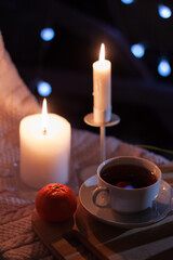 Tea cup on a dark table with candles and bokeh lights in a dark  background