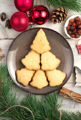Cookies in the shape of a Christmas tree on a plate on a Christmas background. The view from the top. The concept of New Year and Christmas.