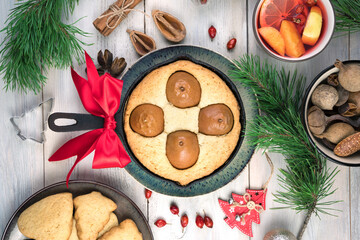 Christmas pastries and mulled wine on a wooden background with pine branches. The concept of New year and Christmas.