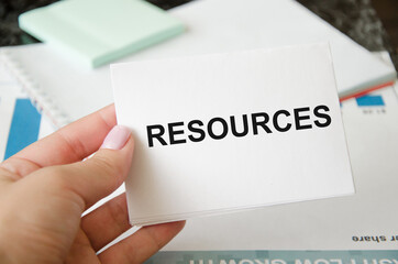 Businesswoman holding a sign with the text Resources. Enterprise resource planning concept. Business structure and many business icons.