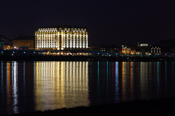 A large building with nice lighting. Embankment. Reflection of lanterns in the water of the river. Kiev city. Cityscape.