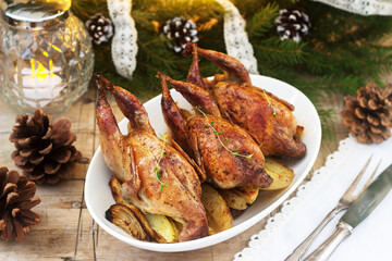 Baked quail with potatoes and onions on a festive background. Rustic style.