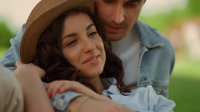 Affectionate couple spending time on picnic. Girl and guy lying on grass