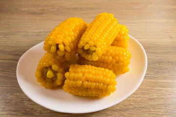Corn lies on canvas. Fresh corn closeup. Corn cob on a plate. Sweet corn on background for food ingredients and cooking concept.