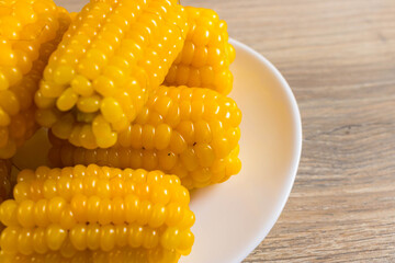 Corn lies on canvas. Fresh corn closeup. Corn cob on a plate. Sweet corn on background for food ingredients and cooking concept.