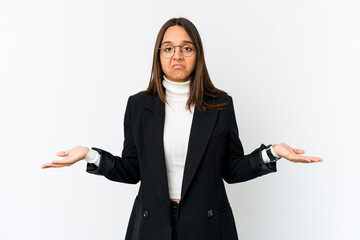Young mixed race business woman isolated on white background doubting and shrugging shoulders in...