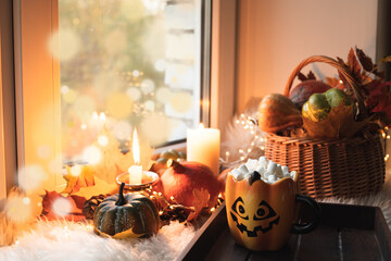 Halloween with pumpkins, coffee with marshmallow on windowsill. Stay at home in lockdown.