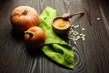 Obraz na płótnie Canvas Creamy pumpkin soup with seeds in wooden bowl