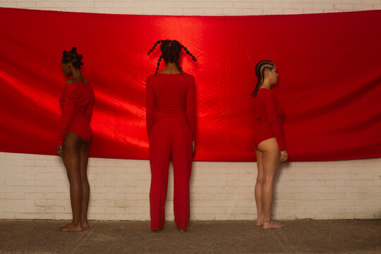 Rear view of three Black models in red
