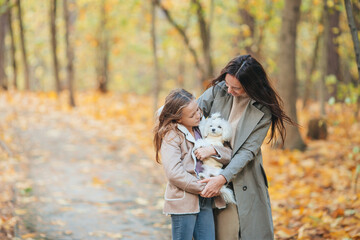 Fototapeta premium Little girl with mom outdoors in park at autumn day