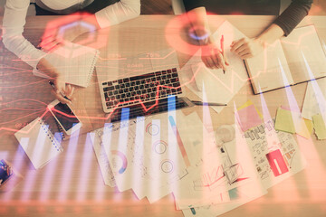 Double exposure of woman hands working on computer and forex graph hologram drawing. Top View. Financial analysis concept.