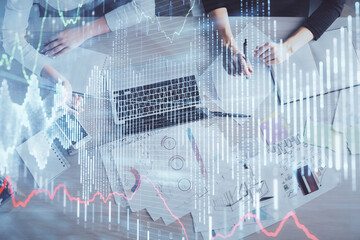 Double exposure of woman hands working on computer and forex graph hologram drawing. Top View. Financial analysis concept.