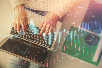 Double exposure of woman hands working on computer and forex chart hologram drawing. Top View. Financial analysis concept.