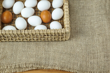raw eggs in a straw basket on a rustic table
