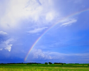 Photo I took in the country of a bright rainbow and clouds after we had a hard rain.