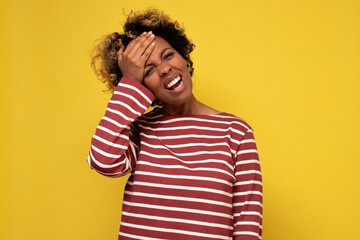Dissatisfied young african woman regrets wrong doing, keeps hand on forehead