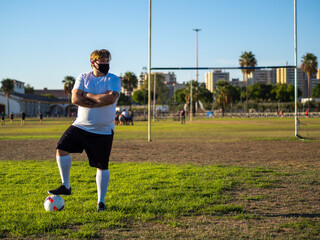 Hombre gordo posando en un campo de futbol vistiendo mascarilla  © David Martínez