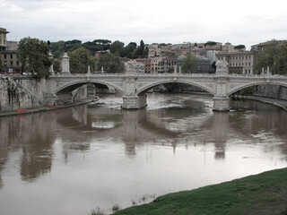 Fototapeta premium Rome, Italy - September 26 2006 - Ponte Vittorio Emanuel II, a bridge over the Tiber river on a cloudy, overcast day. It was designed by Ponte Vittorio Emanuel II. Image has copy space.