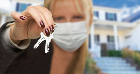 Woman Presenting House Keys Wearing Medical Face Mask
