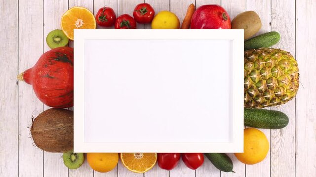Fresh different fruits and vegetables appear under frame with place for text. Stop motion
