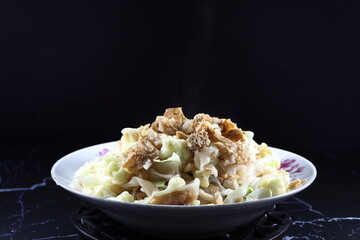 Fried and stirred rice noodle with dried tofu, cutting Chinese cabbage and cauliflower on the plate. Famous vegetarian menu in Asia restaurant. High fiber and low fat menu.