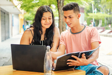Young college friends studying with laptop sitting and studying on campus
