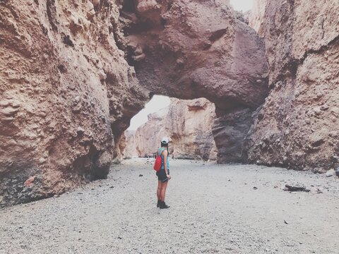 Hiking and exploring a desert to find a rock archway. Death Valley.