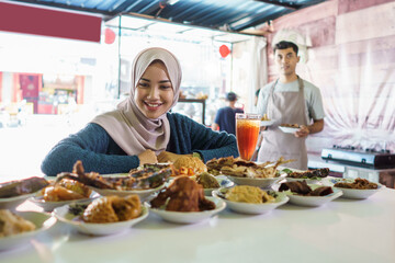 the woman looks at the Padang food she has ordered