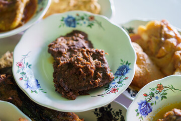 a portrait of rendang food on a plate in a traditional food dish
