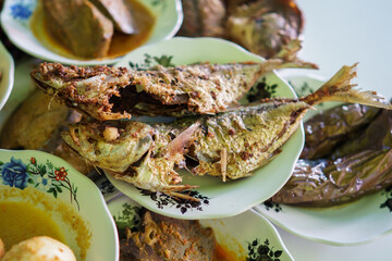 a portrait of fried fish food on a plate in a traditional food dish