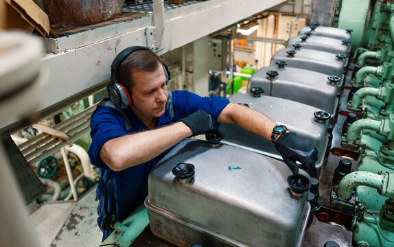 Marine engineer officer reparing vessel engines and propulsion in engine control room ECR. Ship onboard maintenance
