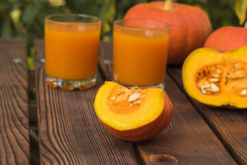 Ripe pumpkins with fresh juice on a wooden table in the autumn garden.