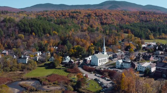 Aerial panorama of small charming ski town of Stowe in Vermont at fall. Stowe Community Church in the middle of the valley