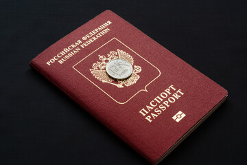 Russian foreign passport with ruble coin on black background