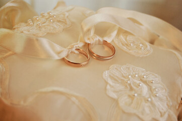 beautiful gold wedding rings on the pillow