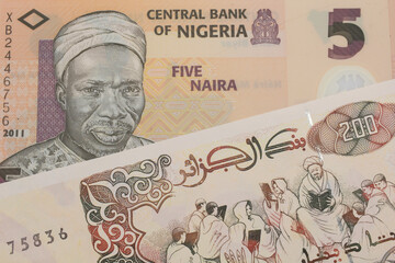 A macro image of a orange, plastic five naira note from Nigeria paired up with a beige 200 Algerian dinar bank note.  Shot close up in macro.