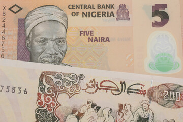 A macro image of a orange, plastic five naira note from Nigeria paired up with a beige 200 Algerian dinar bank note.  Shot close up in macro.