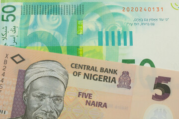 A macro image of a orange, plastic five naira note from Nigeria paired up with a green and white fifty shekel bank note from Israel.  Shot close up in macro.