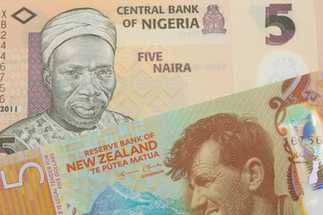 A macro image of a orange, plastic five naira note from Nigeria paired up with a orange, plastic five dollar bill from New Zealand.  Shot close up in macro.