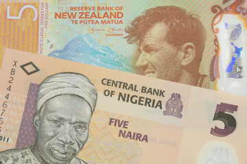 A macro image of a orange, plastic five naira note from Nigeria paired up with a orange, plastic five dollar bill from New Zealand.  Shot close up in macro.