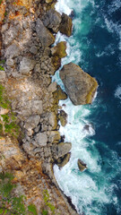 top view of beautiful waves crashing on the rocky island coast