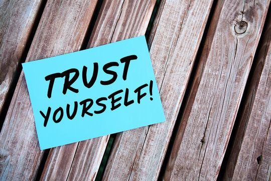 Trust yourself. Motivational or inspirational quote handwritten on paper on a wooden table. Self confidence concept.