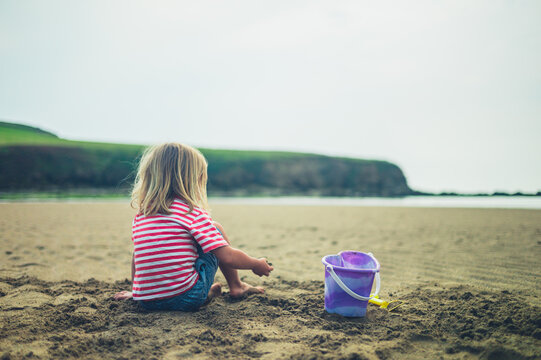Preschooler playing with bucket on the beach