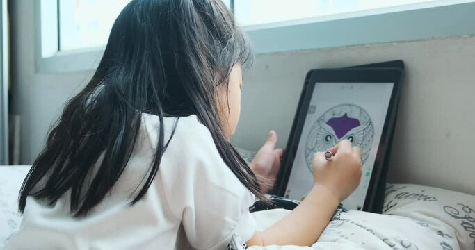 Little child girl use tablet computer drawing colorful cartoon in living room chil education concept